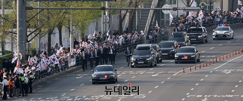 ▲ 윤석열 전 대통령 파면 일주일만인 11일 오후 서울 한남동 관저를 떠나 아크로비스타 사저로 이동하는 윤 전 대통령을 향해 지지자들이 태극기를 흔들고 있다. ⓒ서성진 기자