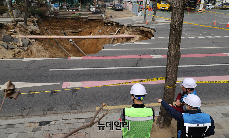 ▲ 서울 강동구 명일동에서 발생한 대형 땅꺼짐(싱크홀) 사고로 오토바이 운전자가 추락한 가운데 지난달 25일 오전 관계자들이 현장을 살피고 있다. ⓒ정상윤 기자