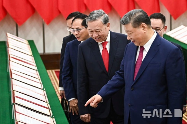 ▲ 시진핑 중국 국가 주석(중국공산당 총서기, 우)이 또럼 베트남공산당 서기장과 회담을 마친 후 베트남 하노이의 당 중앙위원회 청사에서 함께 양국간 체결했던 협정서 사본을 들러보고 있다. 250414 AP/뉴시스. ⓒ뉴시스