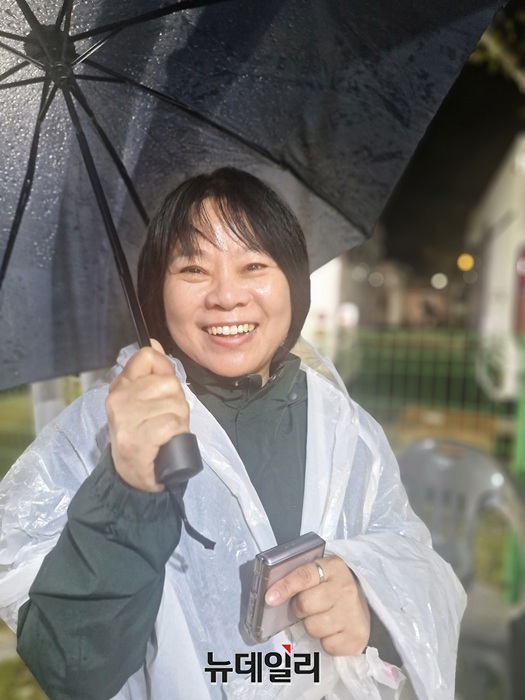 ▲ 우비 차림으로 ‘2025년 클린캠핑 페스티벌’ 공연을 지원하는 김명영 청주시 관광과장이 밝게 웃고 있다.ⓒ양승갑 기자