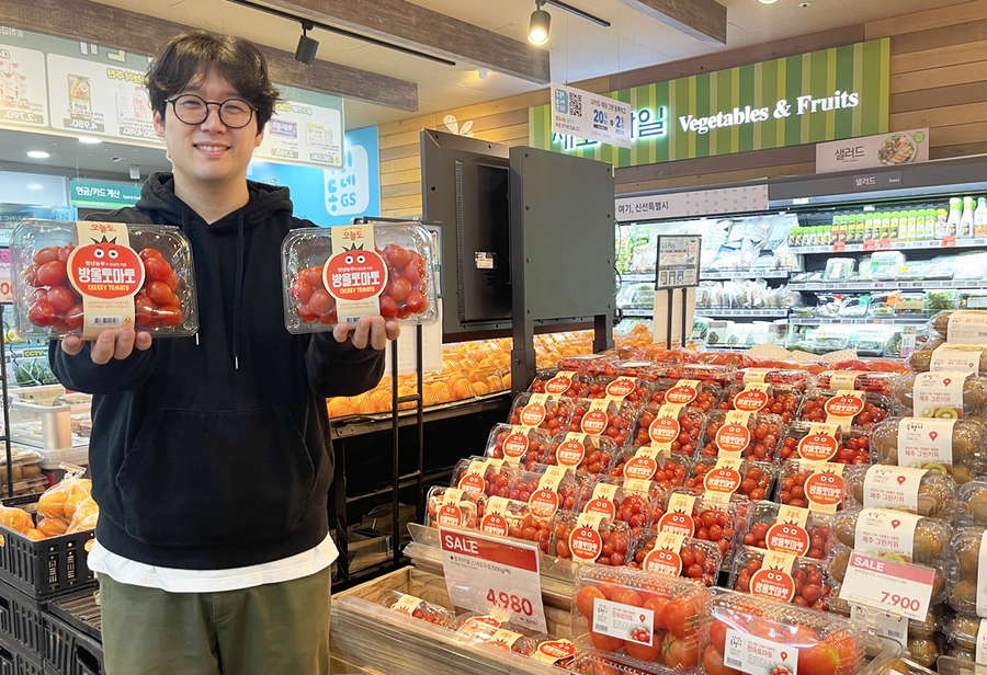▲ GS더프레시 과일 MD가 푸르메소셜팜에서 매입해 판매하고 있는 토마토를 들고 포즈를 취하고 있다ⓒGS더프레시