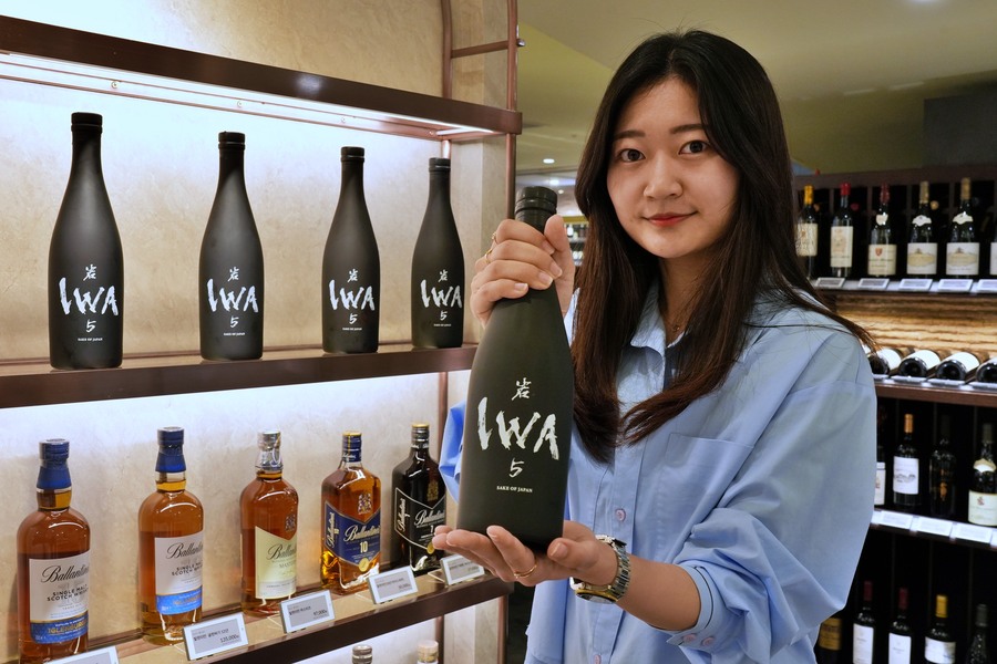 ▲ 롯데백화점 본점 지하 1층 와인매장에서 상품을 들고 있는 모습ⓒ롯데백화점