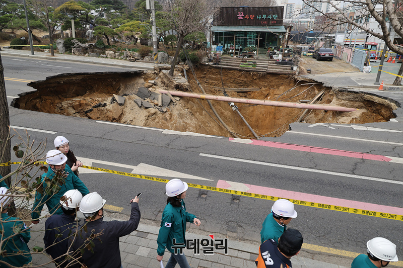 ▲ 3월 24일 오후 서울 강동구 명일동에서 대형 땅꺼짐(싱크홀) 사고가 발생한 가운데 관계자들이 현장을 살피고 있다.ⓒ정상윤 기자