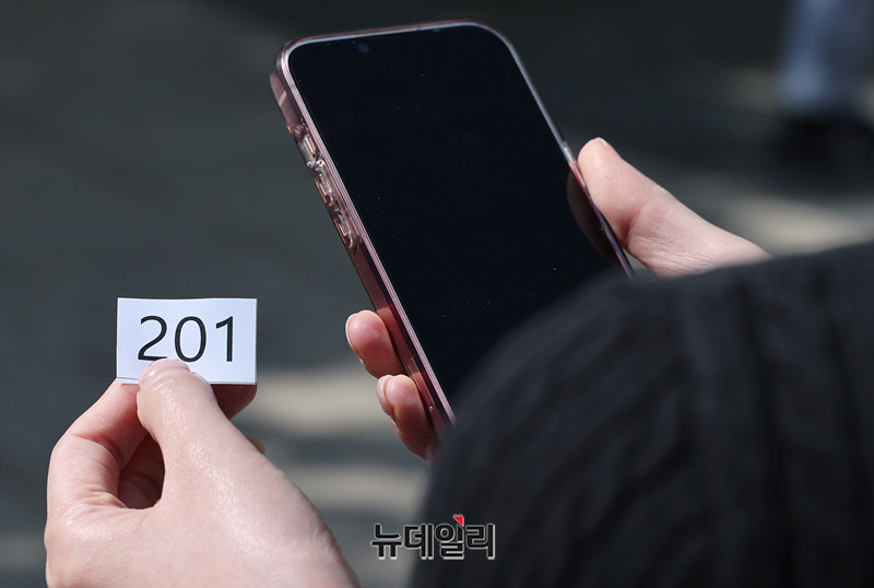 ▲ 한 가입자가 SKT 유심 교체 관련 200번의 대기 번호표를 받고 있다.ⓒ정상윤 기자