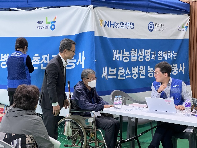 ▲ NH농협생명이 지난 26일 강원도 홍천군 홍천농협 관내에서 2025년 두 번째 농촌의료지원사업을 실시했다. 사진은 검진받는 조합원을 살피는 NH농협생명 김기동 부사장의 모습.ⓒNH농협생명