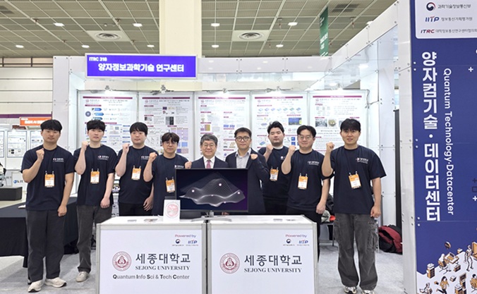 ▲ 세종대 양자정보과학기술연구센터 홍석륜 센터장(가운데)과 물리학과 김근수(오른쪽에서 네 번째) 교수, 연구원들이 전시부스에서 기념촬영을 하고 있다.ⓒ세종대