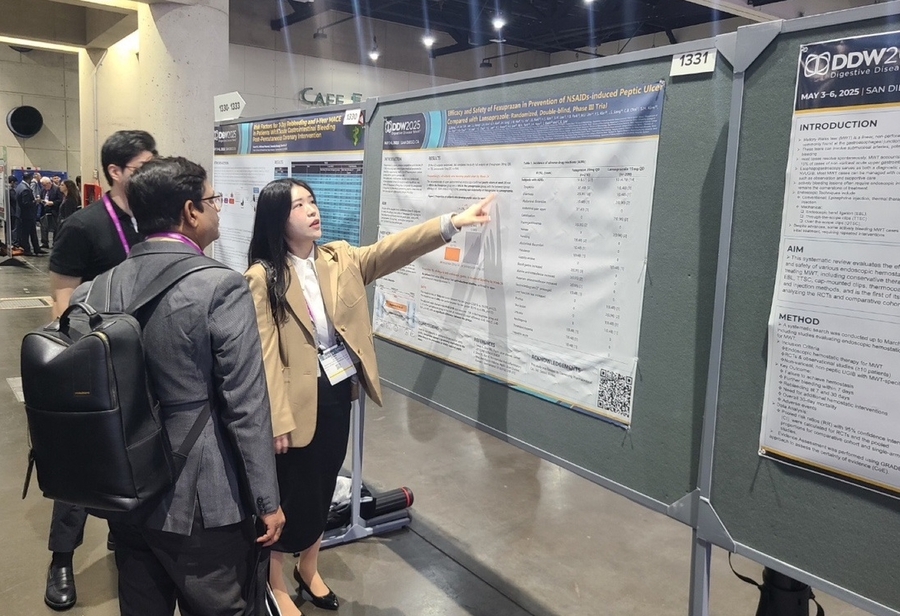 ▲ 해외 의료진(왼쪽)이 펙수클루(펙수프라잔)의 NSAIDs 유도 소화성궤양 예방 임상연구 결과를 보고 있다.ⓒ대웅제약