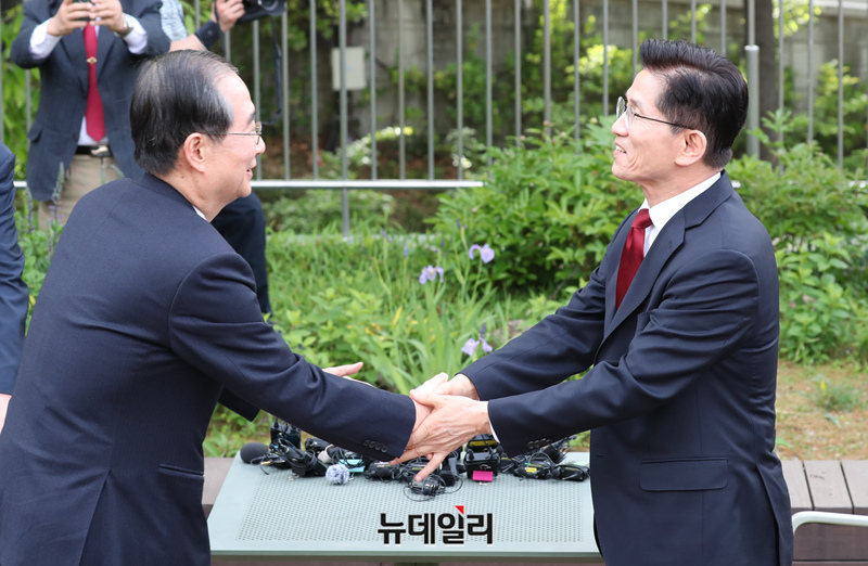 ▲ ⓒ▲ 김문수 국민의힘 대선 후보와 한덕수 무소속 대선 후보가 8일 서울 여의도 국회 강변서재 야외에서 단일화 관련 회동을 하며 악수를 하고 있다. 한덕수 전 총리는 “야권 후보 단일화가 실패할 경우 대선에서 패배할 수밖에 없다”고 강조했고, 김문수 후보는 단일화 협상 이후 정치적 대가를 요구하려는 태도를 비판하며 두 사람의 만남은 결국 빈손으로 끝났다.ⓒ이종현 기자