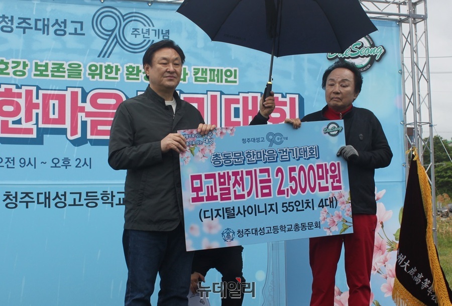 ▲ 오영식 대성고 총동문회장(우)이 청주 대성고등학교 개교 90주년을 기념하는 ‘총동문 한마음 걷기대회 및 미호강 환경정화 캠페인’에서 박일순 대성고 교장에게 2500만원의 학교 발전후원금을 전달하고 있다.ⓒ김정원 기자