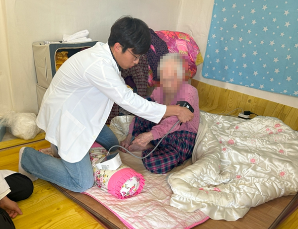 ▲ ‘찾아가는 주치의’ 시범 사업 첫 대상자인 100세 어르신 가정 방문 모습 혈압과 혈당을 측정하며 건강 상태를 점검하는 관리 의사와 전문 인력팀.ⓒ부여군