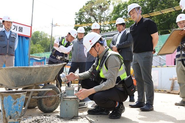 ▲ 롯데건설 직원이 서초 헌인마을 현장에서 차세대 혼화제가 적용된 콘크리트를 테스트하고 있다.ⓒ롯데건설