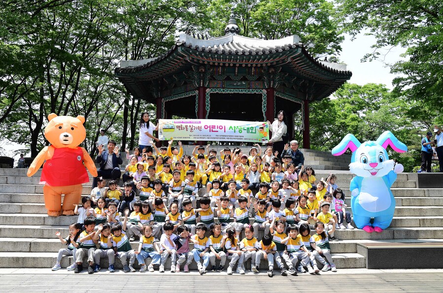 ▲ 14일 서울 남산 일대에서 열린 ‘2025 평화통일기원 어린이 사생대회’에 참석한 어린이들과 한국삭도공업 및 동행연우회 관계자들이 기념촬영을 하고 있다. ⓒ한국삭도공업