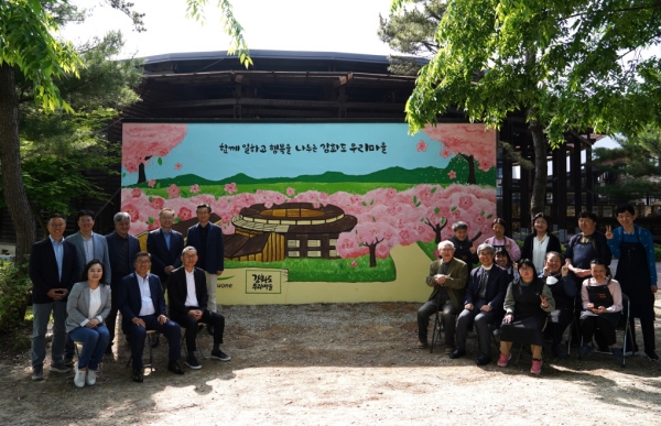 ▲ 15일 인천 강화도에 위치한 발달장애인 직업재활시설 강화도 우리마을 외벽 벽화 앞에서 풀무원 이우봉 총괄CEO(사진 첫 번째 줄 왼쪽 두 번째)와 사업단위 대표들이 강화도 우리마을 설립자 대한성공회 김성수 주교(사진 첫 번째 줄 오른쪽 세 번째), 우리마을 최수재 원장 신부(사진 첫 번째 줄 오른쪽 두 번째), 벽화 채색 작업에 참여한 강화도 우리마을 발달장애인 및 근로자들과 단체 사진을 촬영하고 있다. ⓒ풀무원