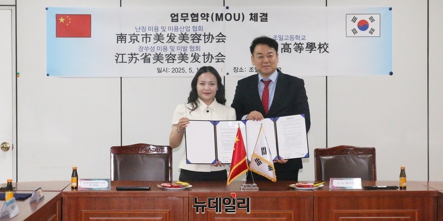 ▲ 중국 강소성 미용 및 헤어디자인 협회의 비서 겸 사무총장인 쑤퉁(SUTONG, 왼쪽)이 16일 최상현 조일고 교장과 미용산업 발전을 위한 협약을 하고 있다.ⓒ뉴데일리