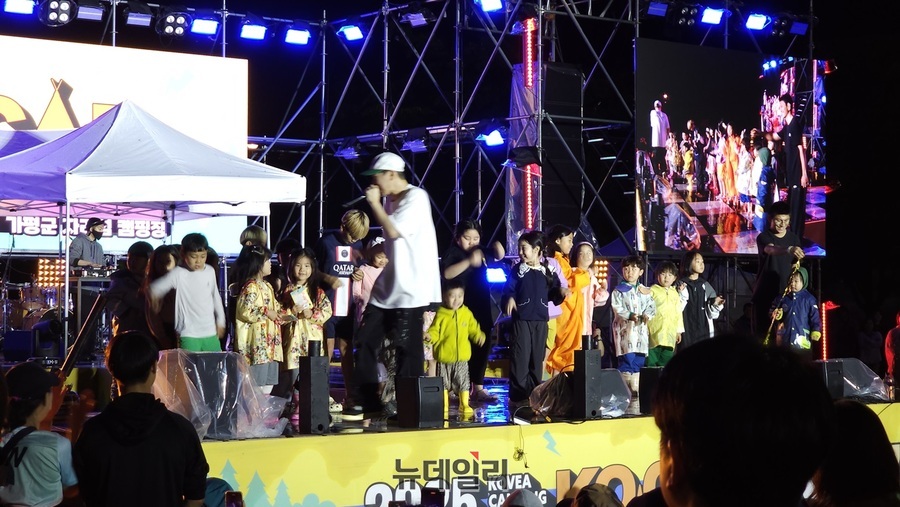 ▲ ‘제19회 2025 코베아 캠핑 페스티벌(KOCAF) 축하무대에서 힙합 가수 배치기 탁이 어린이들과 함께 즐거운 시간을 갖고 있다.ⓒ김정원 기자