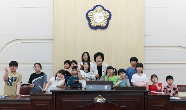▲ 견학 온 지역아동센터 학생들이 본회의장에서 의장석 체험을 하고 있다.ⓒ동구의회