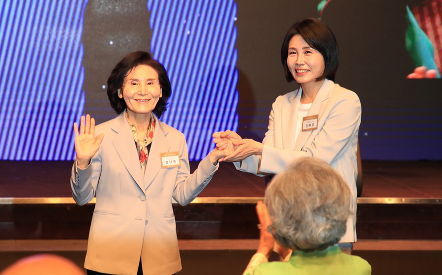 ▲ 이재명 더불어민주당 대선 후보의 부인 김혜경 여사와 김문수 국민의힘 대선후보의 부인 설난영(왼쪽) 여사가 12일 서울 중구 신라호텔에서 열린 중앙신도회 창립 70주년 기념식에서 손을 맞잡고 있다. ⓒ조계종 제공