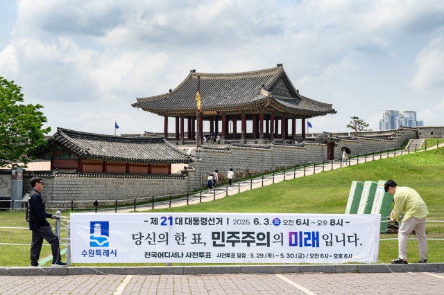 ▲ 수원시 관계자들이 투표 참여를 독려하는 문구가 적힌 현수막을 설치하고 있다. ⓒ수원시 제공