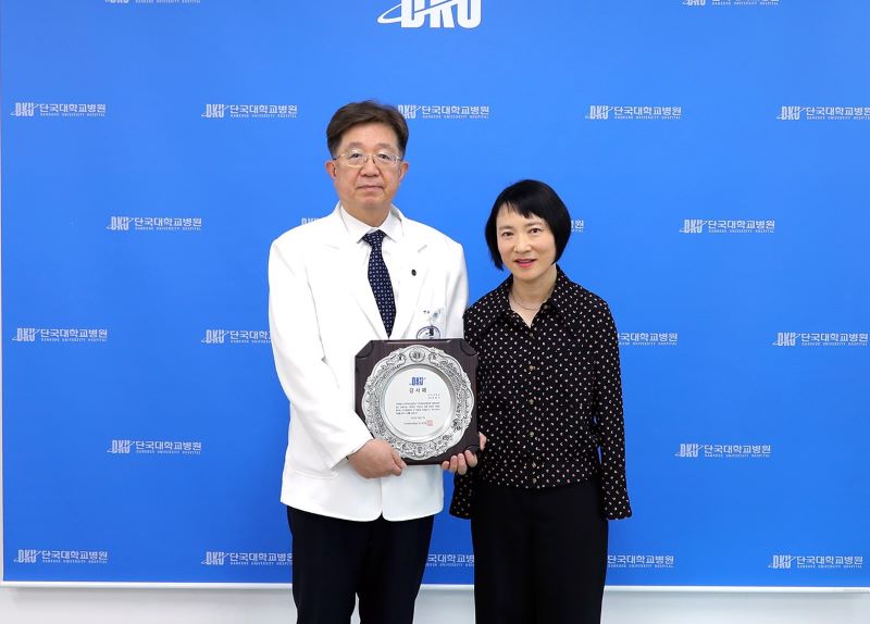 ▲ 김재일(오른쪽) 단국대병원장이 작품을 기증한 오순이 교수에게 감사패를 전달하고 있다.ⓒ단국대병원