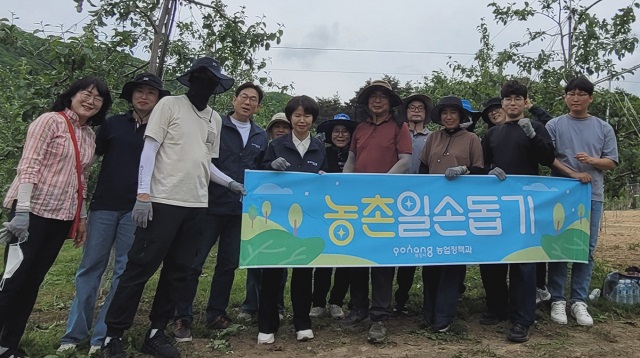 ▲ 포항시 농업정책과 직원들이 지난 21일 죽장면 소재 한 사과농가서 적과 작업을 돕고 기념촬영을 하고 있다.ⓒ포항시