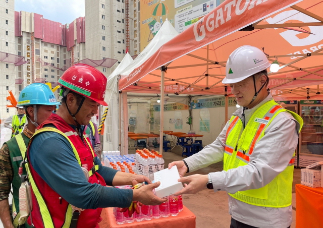 ▲ 황준하 현대건설 CSO가 근로자에게 이온음료, 쿨링스프레이를 전달하고 있다. ⓒ현대건설