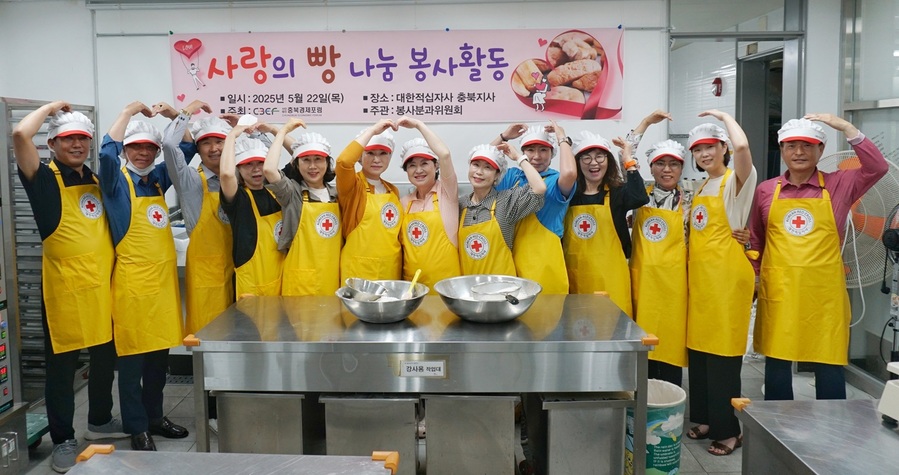 ▲ 충북경제포럼 회원들의 제빵봉사활동 중 머리 위로 하트를 만들어 보이고 있다.ⓒ충북적십자사
