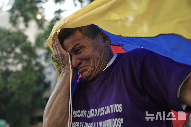 ▲ 베네수엘라 카라카스에서 유월절을 맞아 열린 '십자가의 길' 의식에 참여한 정치범 수감자의 가족이 정치범들의 석방을 촉구하며 들고 있던 국기로 눈물을 훔치고 있다. 250415 AP/뉴시스. ⓒ뉴시스