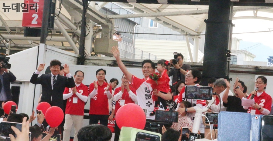 ▲ 김문수 후보가 28일 오후 경산공설시장 유세 연단에 올라 어린아이를 앉고 손을 들어 인사하고 있다.ⓒ뉴데일리