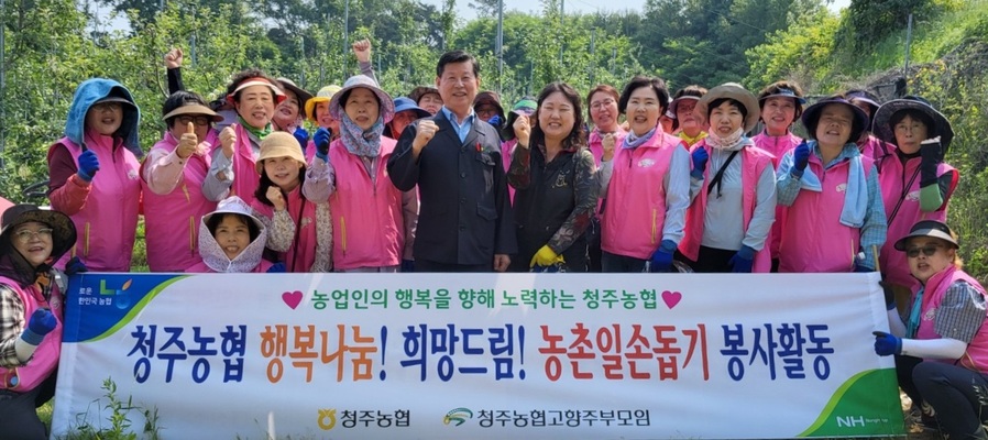 ▲ 이화준(앞줄 가운데) 조합장과 임직원들이 청주농협 고향주부모임 회원들과 사과 재배 농가에서 기념촬영을 하고 있다.ⓒ충북농협