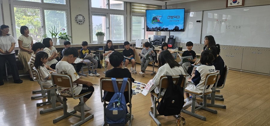 ▲ 지난 28일 서귀포시 사계초등학교의 그림책‘산방덕이’출판 전시회애 참석한 학생들이 그림책의 작품에 관해 설명하고 있다. ⓒ제주특별자치도교육청 제공