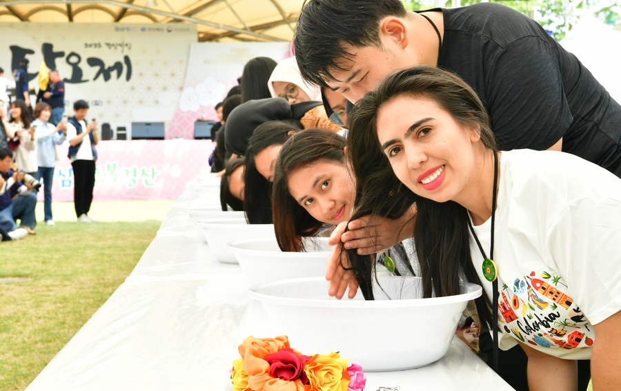 ▲ 외국인 유학생의 창포머리감기 시연 장면.ⓒ경산시