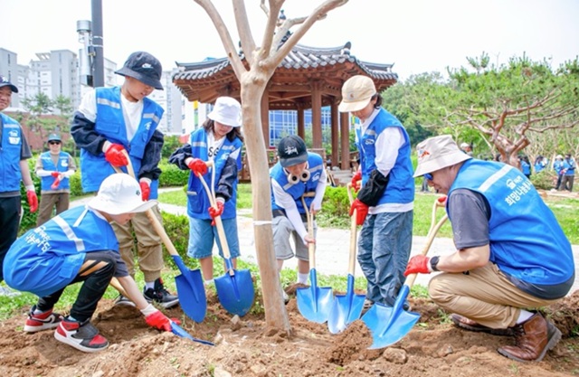 ▲ SBI저축은행 김문석 대표이사(오른쪽 첫번째)가 SBI희망나눔 봉사단원 및 자녀들과 함께 나무를 심고 있다.ⓒSBI저축은행