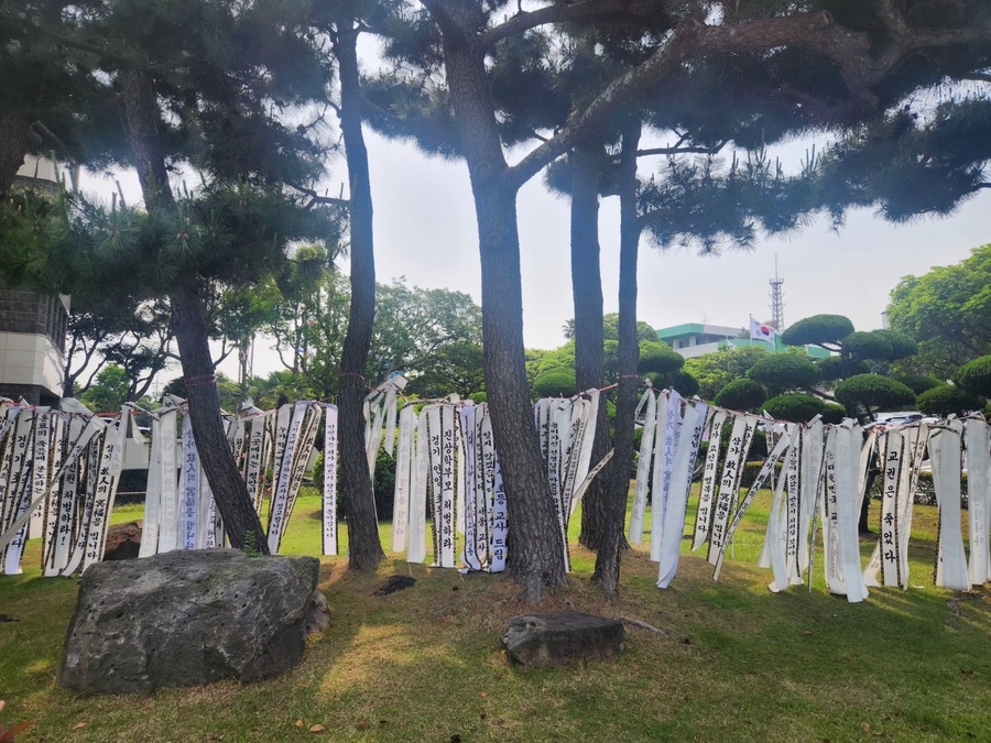 ▲ 지난달 22일 숨진 고 현승준 교사를 추모하는 화환에 적시된 추모글이 제주특별자치도교육청 정원에 게시되어 있다. ⓒ노재균 기자