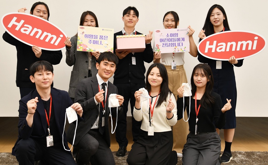 ▲ 한미사이언스와 한미약품 직원들이 소아암 환아를 위해 직접 제작한 히크만 주머니를 들고 기념촬영을 하고 있다. ⓒ한미그룹