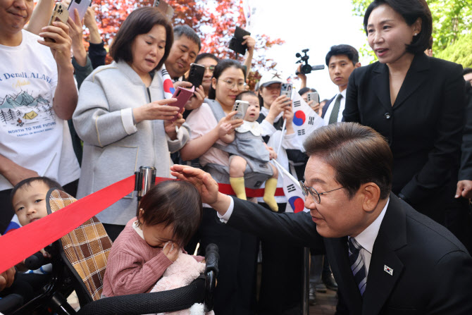 ▲ 이재명 (맨 오른쪽)대통령이 4일 인천 계양구 사저 앞에서 지역주민들의 환호속에 어린아이와 인사를 나누고 있다.ⓒ 뉴시스 제공