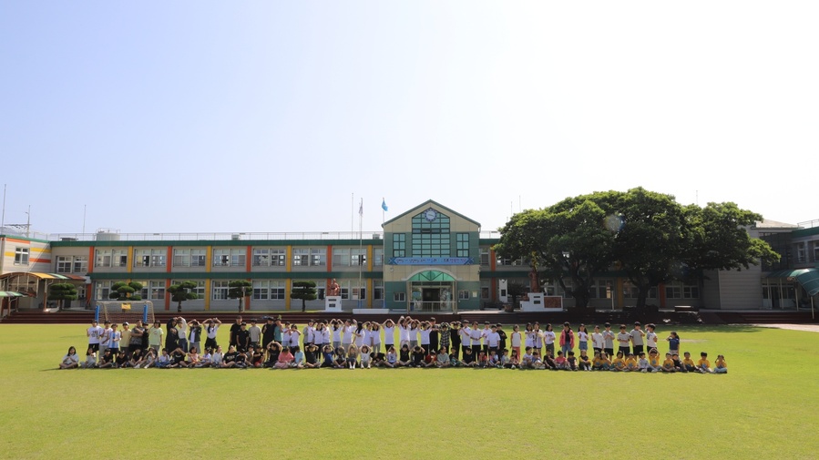 ▲ 제주 세화초등학교 구성원들이 학교를 배경으로 기념촬영을 하고 있다. ⓒ제주 세화초등학교 제공