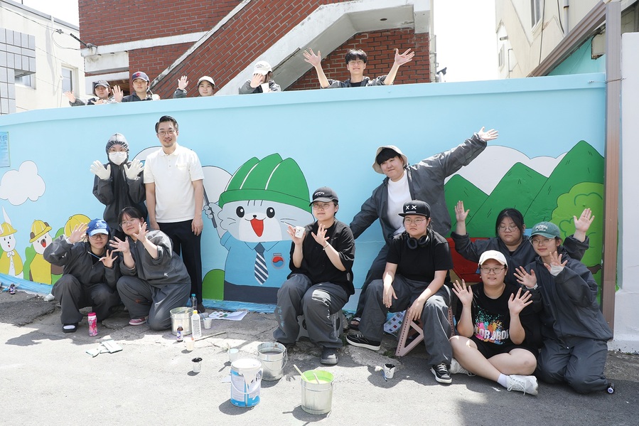 ▲ 박재윤 학과장과 학생들이 벽화그리기를 마치고 기념사진을 촬영하고 있다.ⓒ영남이공대