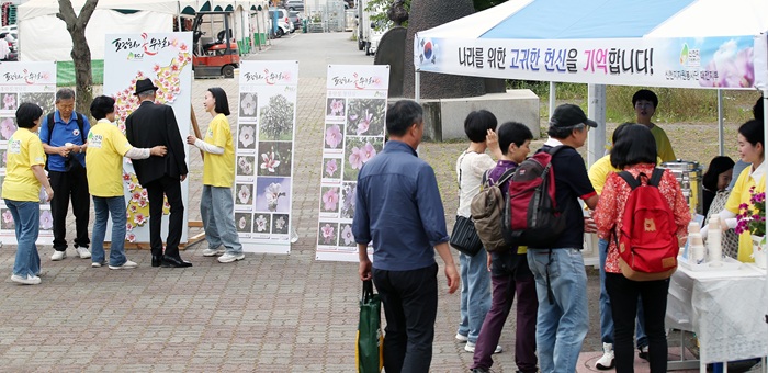 ▲ 신천지 자원봉사단 대전지부가 제70회 현충일인 6월 6일, 월드컵경기장역 현충원 환승 버스정류장에서 순국선열을 기리기 위한 무궁화 체험 행사를 진행하고 있다.ⓒ신천지