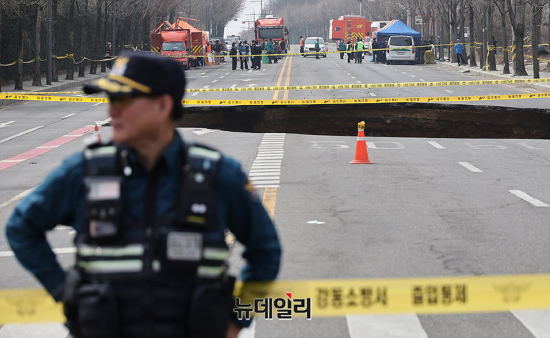 ▲ 서울 강동구 명일동에서 발생한 대형 땅꺼짐(싱크홀) 사고로 오토바이 운전자가 추락한 가운데 3월 25일 오전 관계자들이 현장을 통제하고 구조작업을 진행하고 있다. ⓒ정상윤 기자