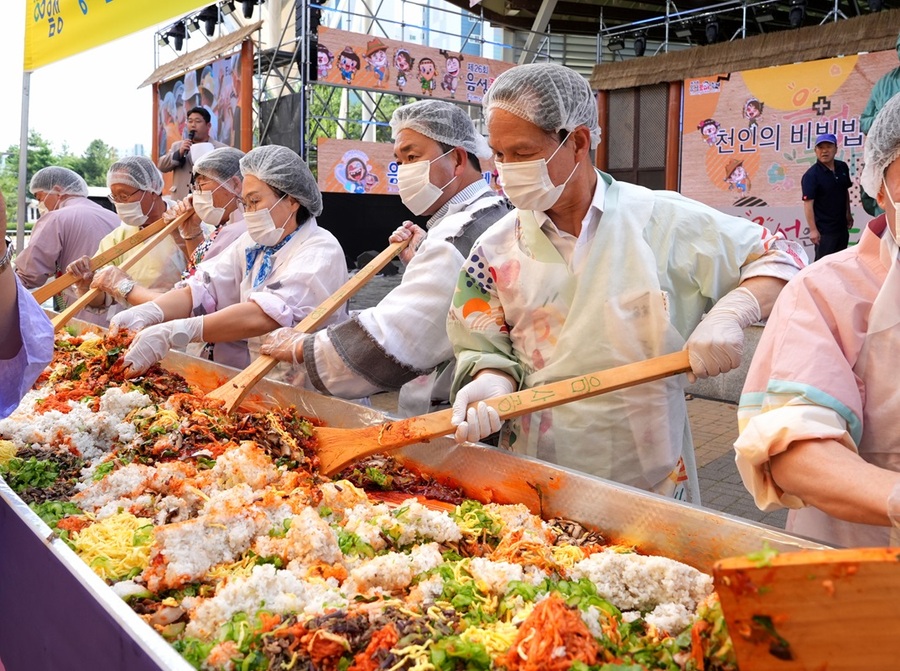 ▲ 음성품바축제의 하이라이트 중 하나인 조병옥 음성군수 등 방문객들이 함께 만든 ‘천인 비빔밥’ 퍼포먼스가 펼쳐져 큰 호응을 얻었다. 행사장에서는 1천 명이 동시에 먹을 수 있는 대형 비빔밥이 즉석에서 비벼져 나눠졌고, 전국에서 모인 각설이 예능단의 흥겨운 공연이 이어지며 분위기를 달궜다. 제24회 음성품바축제가 11일부터 오는 15일까지 닷새간 음성 설성공원과 꽃동네 일원에서 화려하게 열린다.ⓒ음성군