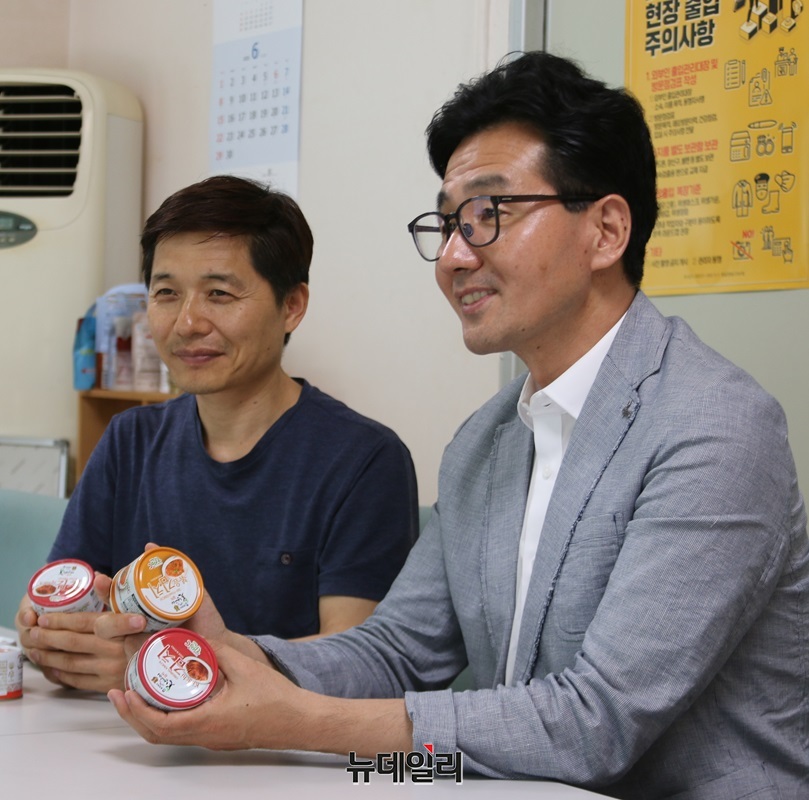 ▲ 김주옥 ㈜시즈너 이사와 연성일 충북도 농식품유통과 농식품산업팀장이 못난이김치캔을 들고 그동안 사업 추진과정에 관해 설명하고 있다.ⓒ이길표 기자