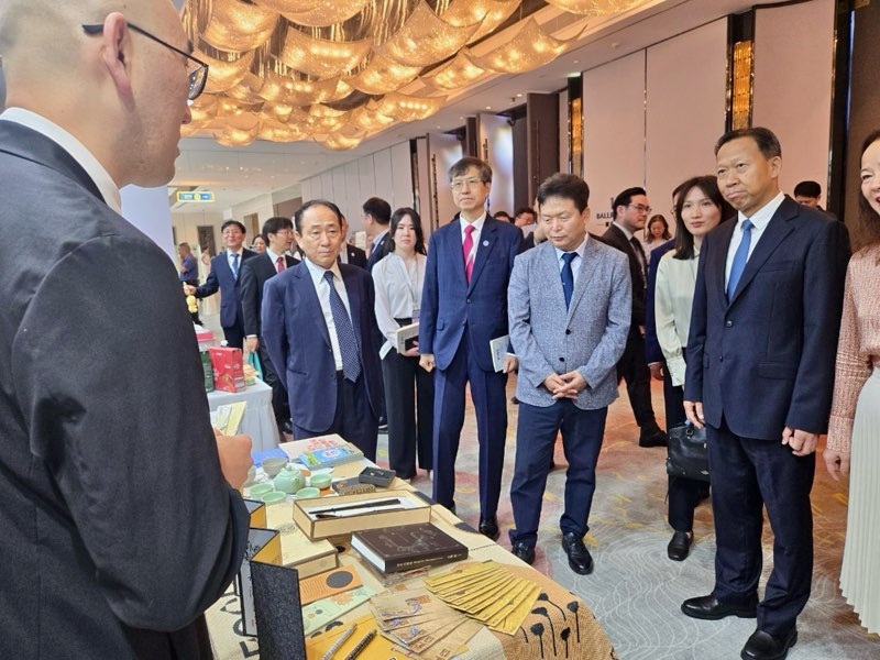 ▲ 2025 한중일 경제 심포지엄 참석 내빈들이 17일 청주비엔날레 홍보부스에서 청주시 직원으로부터 설명을 듣고 있다. ⓒ청주시