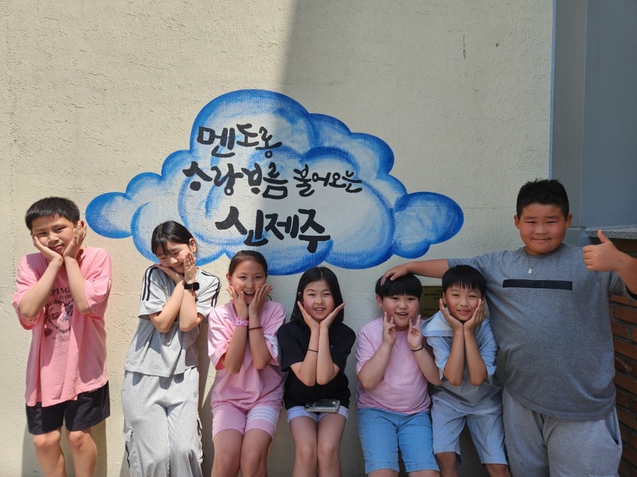 ▲ 신제주초등학교 학생들이 학교 외벽에 아로새겨진 제주어 벽화 앞에서 사진을 찍고 있다. ⓒ제주특별자치도교육청 제공