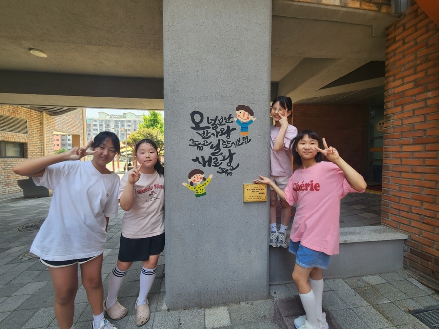 ▲ 신제주초등학교 학생들이 학교 외벽에 아로새겨진 제주어 벽화 앞에서 사진을 찍고 있다. ⓒ제주특별자치도교육청 제공