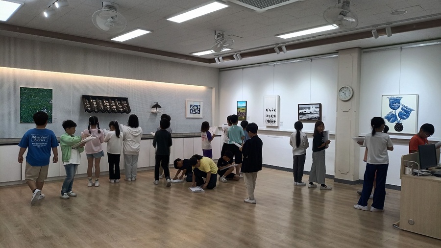▲ 하귀초등학교 학생들이‘학생 참여형 찾아가는 미술관–제주를 보고 그리다’전시회에 전시된 작품을 관람하고 있다. ⓒ제주특별자치도교육청 제공