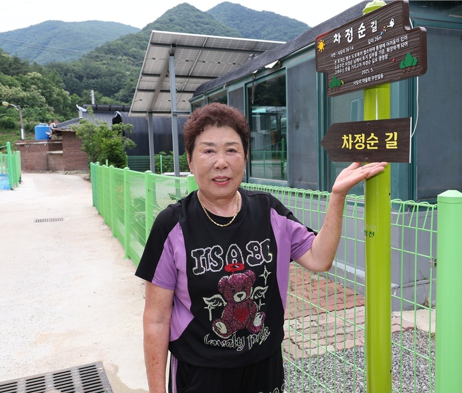 ▲ 괴산군 청천면 사담1리 노인회장 차정순 씨(78세)가 자신의 사유지 27㎡를 군에 기부해 ‘차정순 길’로 명명된 길에서 기념촬영을 하고 있다. ⓒ괴산군