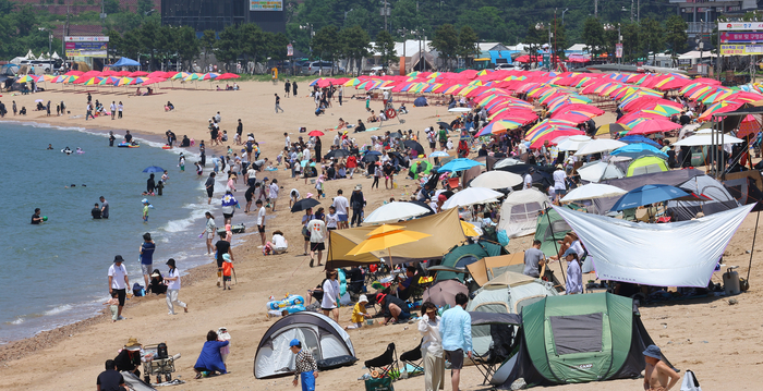▲ 22일 인천 중구 왕산해수욕장을 찾은 시민들이 더위를 식히고 있다.ⓒ 연합뉴스 제공
