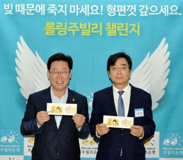▲ 2015년 5월 서울시 시민청에서 '주빌리 은행' 출범식이 열렸다. 사진은 주빌리 은행 공동 은행장을 맡았던 당시 이재명 성남시장(왼쪽)과 유종일 한국개발연구원 국제정책대학원 교수의 모습ⓒ연합뉴스