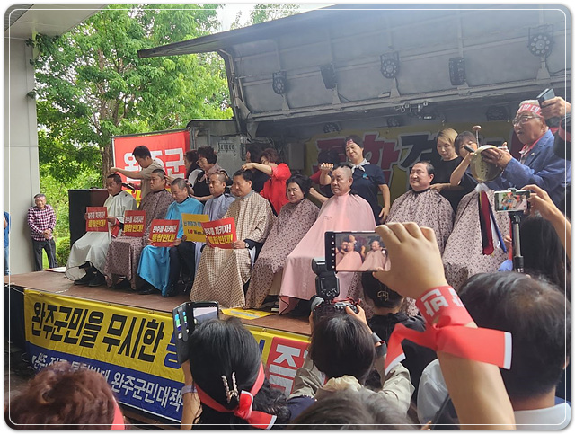 ▲ ⓒ김관영 전북도지사가 오늘(25일)10시 전북도내 시·군 방문 마지막 일정으로 완주군을 찾은 가운데 완주·전주 통합에 반대하는 군의원들이 무대차량에 올라 삭발을 강행하고 있다. 김성수기자