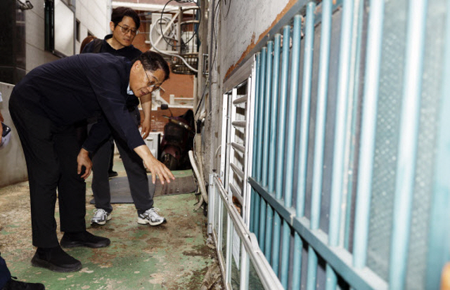 ▲ 황상하 SH공사 사장이 지난 24일 서울시 관악구 신림동 일대 반지하 주택을 방문해 차수판과 개폐형 방범창이 제대로 작동하는지 살펴보고 있다.ⓒSH